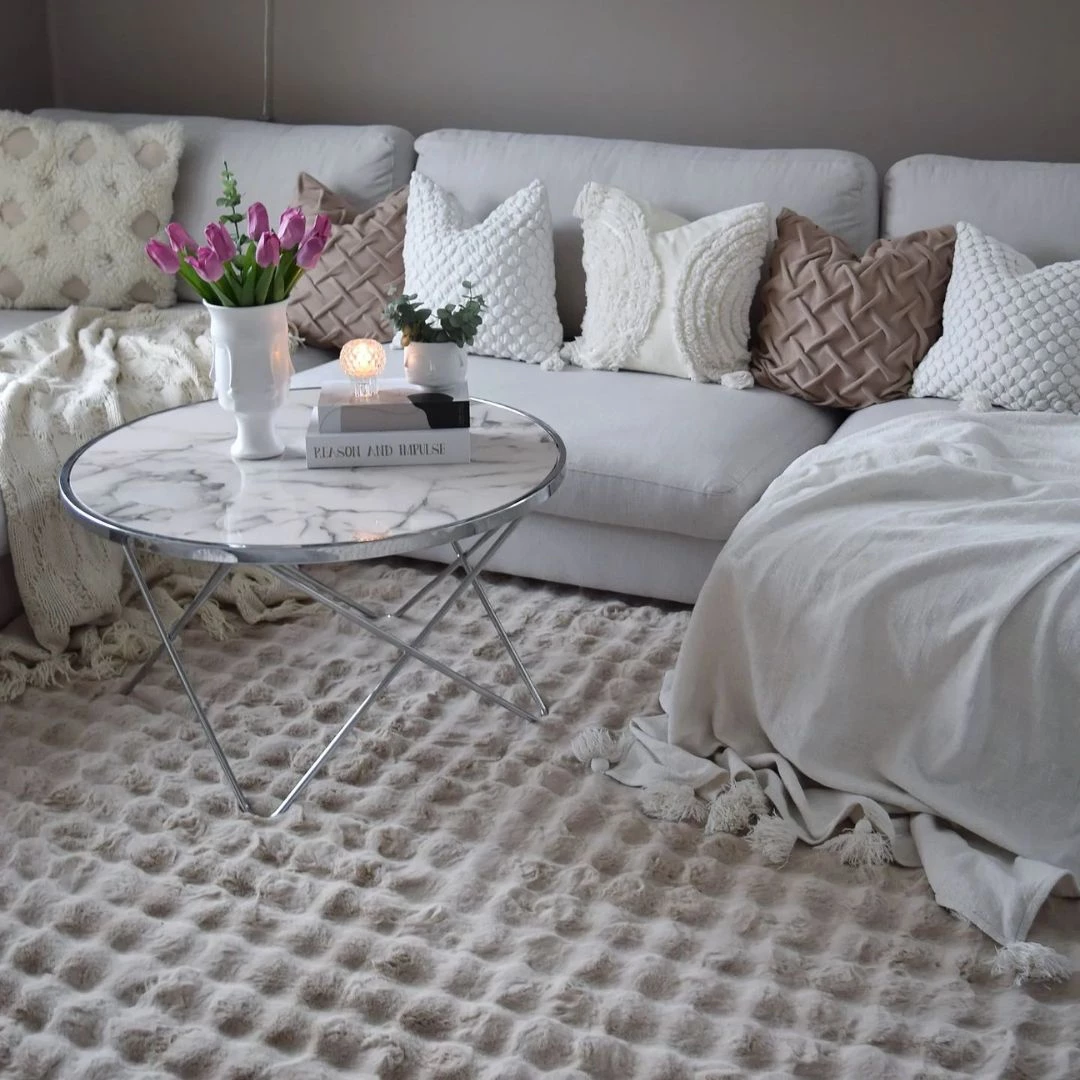 Moderne tæppe i bløde beige farver perfekt til lysegrå sofa.