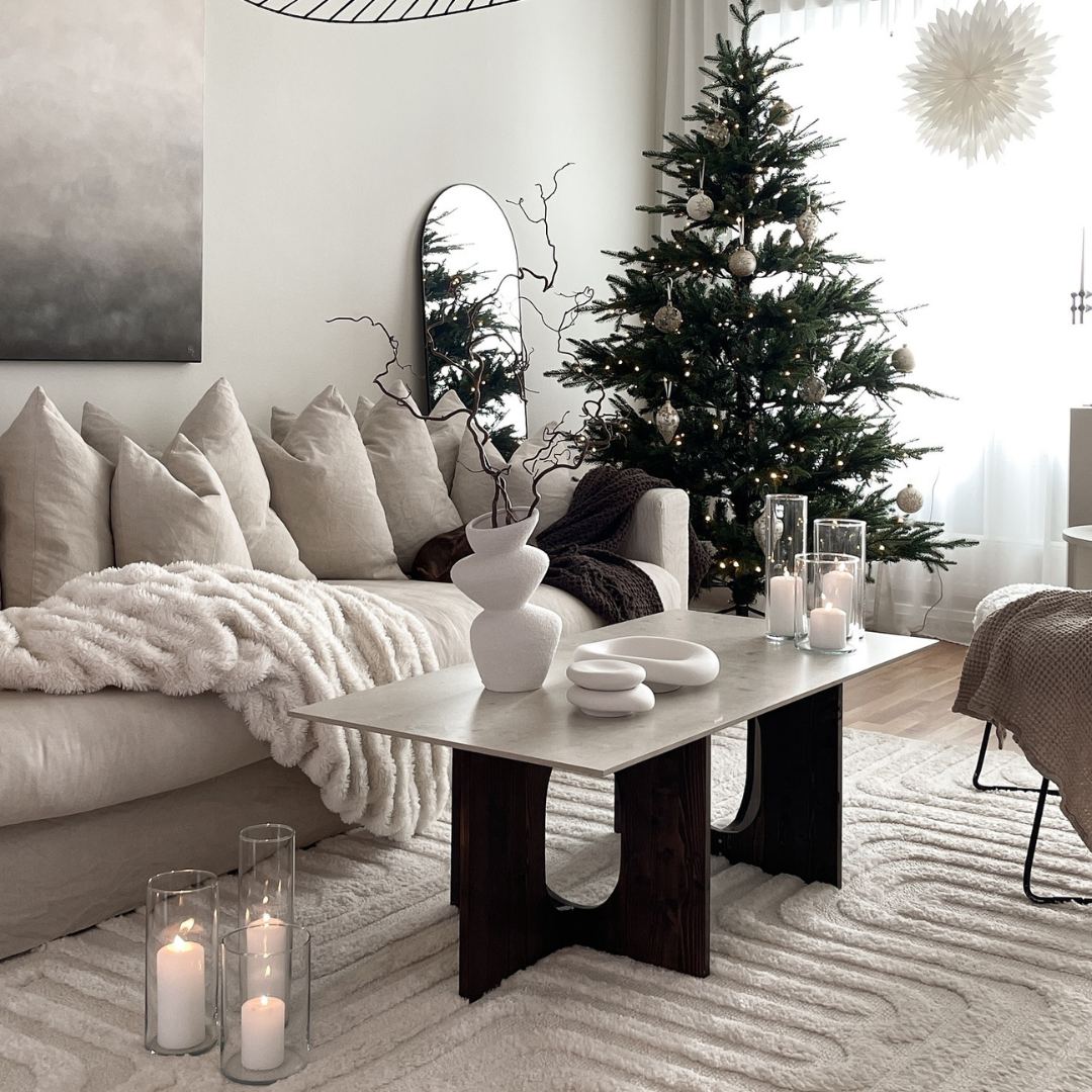 Modern julmatta under julgran i vackert vardagsrum i japandi inredningsstil.